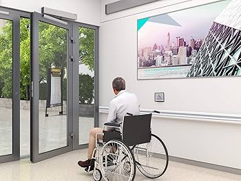 ersona en silla de ruedas utilizando acceso adaptado en edificio residencial