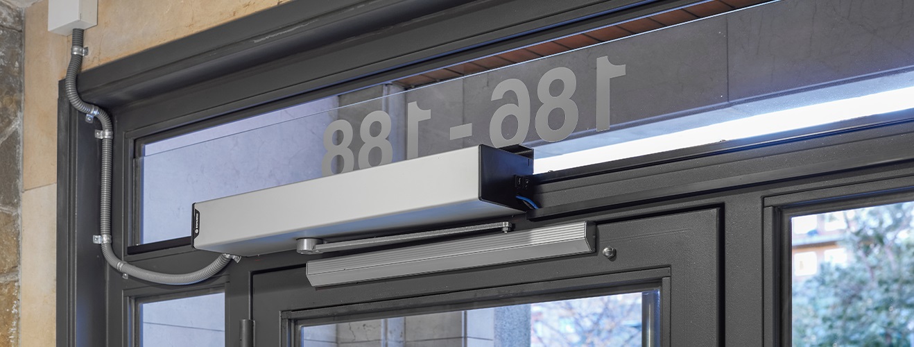 Operador automático instalado en puerta de comunidad en Barcelona para cumplir normativa de accesibilidad